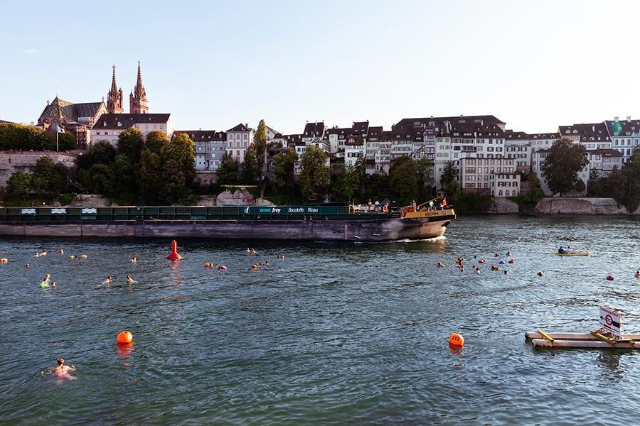 Figure 3: Swimmers in the Rhine next to a large moving vessel. Buoys highlight the area assigned to swimmers. (Image: Lucía deMosteyrín, 2019)